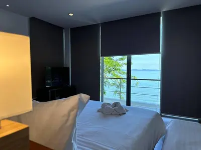 a bedroom with a white bed with a large window at 4bedroom Villa Siray Beach Front in Phuket Town