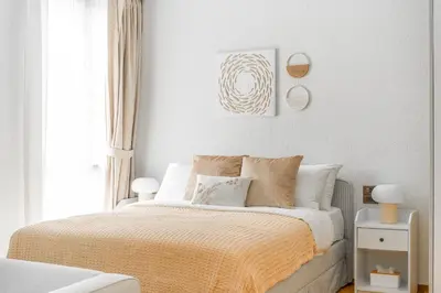 a white bedroom with a bed with a yellow blanket at Title Halo Tenderness Naiyang Pool View Gym in Nai Yang Beach