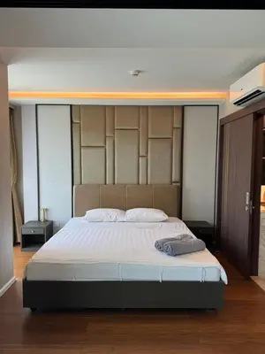 a bedroom with a large bed with a large headboard at Mida Grande Resort Surin by Mill in Surin Beach