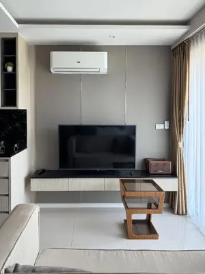 a living room with a flat screen tv on a wall at Mida Grande Resort Surin by Mill in Surin Beach