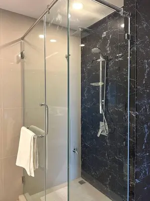 a shower with a glass door in a bathroom at Mida Grande Resort Surin by Mill in Surin Beach