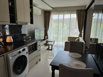 a kitchen and dining room with a table and a dishwasher at Mida Grande Resort Surin by Mill in Surin Beach
