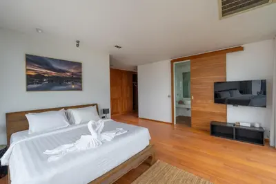 a bedroom with a white bed and a flat screen tv at Eva Beach Villa\u62c9\u5a01\u4e09\u5367\u5168\u6d77\u666f\u522b\u5885 in Ban Saiyuan (1)