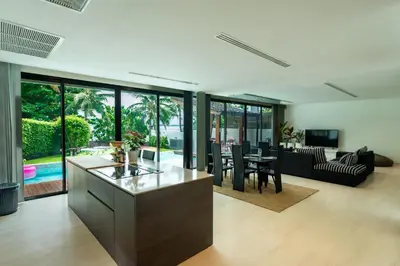 an open kitchen and living room with a table and chairs at Eva Beach Villa\u62c9\u5a01\u4e09\u5367\u5168\u6d77\u666f\u522b\u5885 in Ban Saiyuan (1)