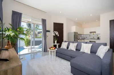 a living room with a blue couch and a kitchen at 1 Bedroom Villa in Rawai - v19 t in Ban Saiyuan (1)