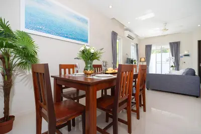 a dining room and living room with a wooden table and chairs at 1 Bedroom Villa in Rawai - v19 t in Ban Saiyuan (1)