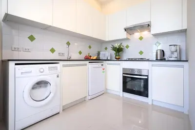 a white kitchen with a washer and dryer at 1 Bedroom Villa in Rawai - v19 t in Ban Saiyuan (1)