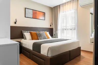a bedroom with a large bed with orange pillows at Title V Summer Dream Pool View Gym Hammam in Rawai Beach
