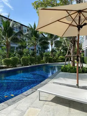 an umbrella and a bench next to a swimming pool at Title V Summer Dream Pool View Gym Hammam in Rawai Beach