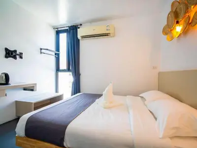 a bedroom with a bed and a window at The Thai Guesthouse and Hostel in Patong Beach