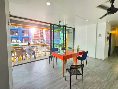 a dining room with a red table and chairs at The Thai Guesthouse and Hostel in Patong Beach