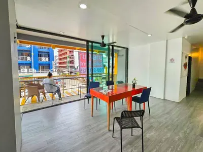a dining room with a red table and chairs at The Thai Guesthouse and Hostel in Patong Beach