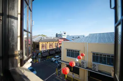 a view from a window of a building with red balloons at The Rommanee Classic Guesthouse in Phuket Town