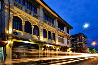 a building on a city street with streaks of lights at The Rommanee Classic Guesthouse in Phuket Town