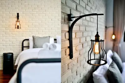 a bedroom with a bed and a brick wall at The Rommanee Classic Guesthouse in Phuket Town