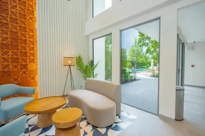 a living room with a table and a chair and a table and a tablektop at Laguna Lakeside apartments with panoramic view in Bang Tao Beach