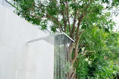 a shower built into a wall next to a tree at Laguna Lakeside apartments with panoramic view in Bang Tao Beach