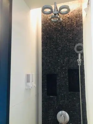 a bathroom with a shower with a tile wall at Kata Beach Guesthouse-The Beach Condo in Kata Beach