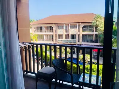 a room with a balcony with a building at Kata Beach Guesthouse-The Beach Condo in Kata Beach