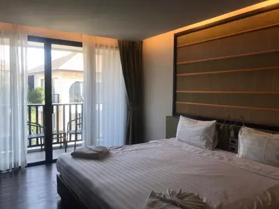 a bedroom with a large bed and a balcony at Kata Beach Guesthouse-The Beach Condo in Kata Beach