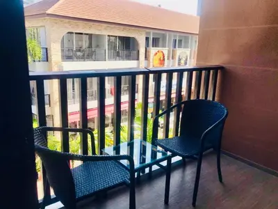 two chairs and a table on a balcony at Kata Beach Guesthouse-The Beach Condo in Kata Beach