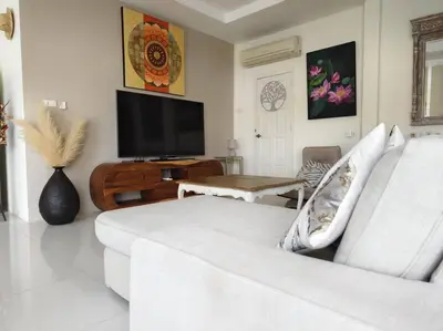 a living room with a white couch and a tv at Villa 3 Chambres avec piscine, Rawai, Phuket in Ban Saiyuan (1)
