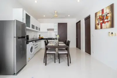 a kitchen with a dining table and a refrigerator at 2 Bedrooms Villa in Rawai - v6 t in Ban Saiyuan (1)