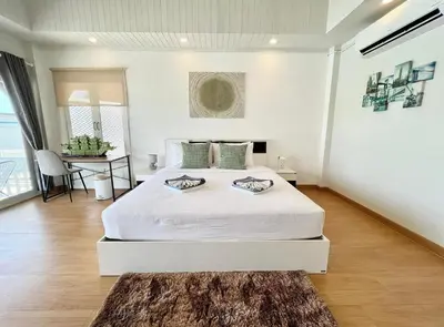 a white bedroom with a large bed and a rug at Moonlight Panorama Seaview House by RESAVA in Surin Beach