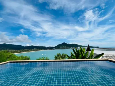 a swimming pool with a view of the ocean at Moonlight Panorama Seaview House by RESAVA in Surin Beach