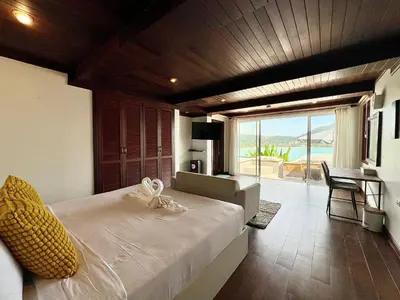 a bedroom with a bed with a view of the ocean at Moonlight Panorama Seaview House by RESAVA in Surin Beach