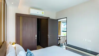 a bedroom with a bed and a tv on the wall at Apartment 2 bedrooms on Surin in Surin Beach