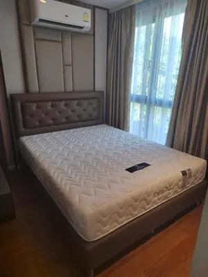 a bed in a room next to a window at Apartment 2 bedrooms on Surin in Surin Beach