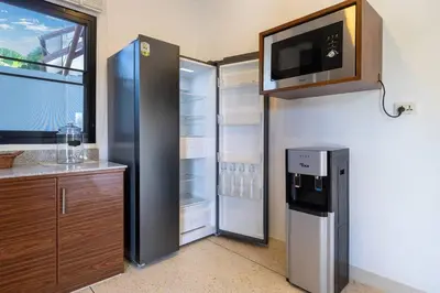 a kitchen with a refrigerator and a microwave at Golden Sands Villa only 15 minutes walk to beach in Surin Beach