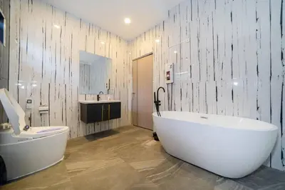 a bathroom with a large white tub and a sink at Golden Sands Villa only 15 minutes walk to beach in Surin Beach