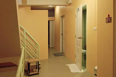 a hallway with a stairway leading to a bathroom at Salika Hostel Patong Phuket in Patong Beach