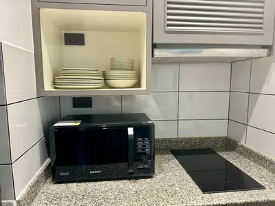 a microwave in a kitchen with plates in a cabinet at Allamanda Laguna Phuket 2 bedroom apartment Bang Tao Beach in Laguna Phuket