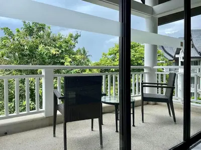 a patio with a table and chairs on a balcony at Allamanda Laguna Phuket 2 bedroom apartment Bang Tao Beach in Laguna Phuket