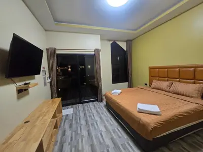 a bedroom with a bed and a flat screen tv at Khumkatang Resort & Restaurant in Ban Bang Rong