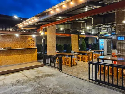 a restaurant with tables and chairs on a patio at Khumkatang Resort & Restaurant in Ban Bang Rong