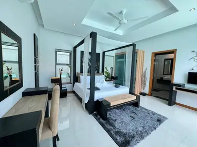 a bedroom with a bed and a table and a couch at Aromdee 2 Villa by G Estate Phuket in Ban Saiyuan (1)