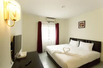 a bedroom with a bed with a swan on it at Paripas Express Patong in Patong Beach