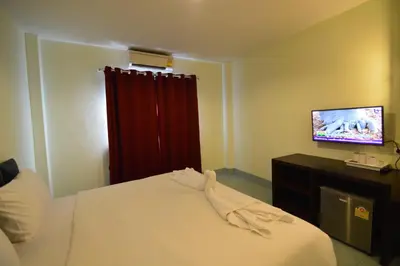 a hotel room with a bed and a television at Paripas Express Patong in Patong Beach