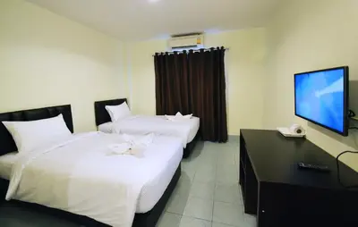 a hotel room with two beds and a flat screen tv at Paripas Express Patong in Patong Beach