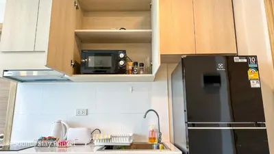 a kitchen with a black refrigerator and a microwave at Soulful Stay Phuket -Distant Seaview and Mountain View Retreat, Patong in Patong Beach
