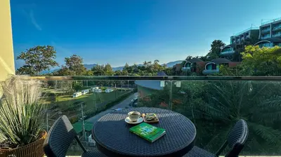 a table with a book on top of a balcony at Soulful Stay Phuket -Distant Seaview and Mountain View Retreat, Patong in Patong Beach