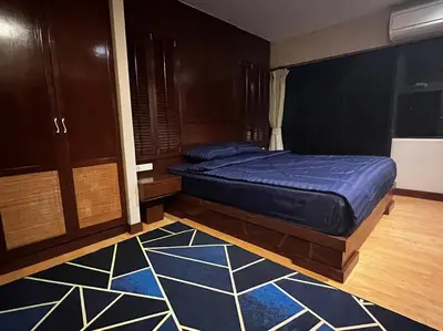 a bedroom with a bed with a blue comforter at Patong Tower Apartment - AMP in Patong Beach