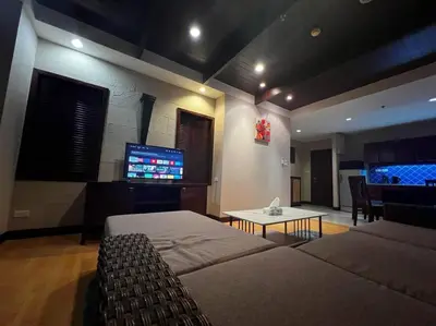 a living room with two beds and a flat screen tv at Patong Tower Apartment - AMP in Patong Beach