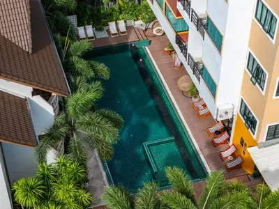 an overhead view of a swimming pool in a hotel with palm trees at Buasri Boutique Patong in Patong Beach