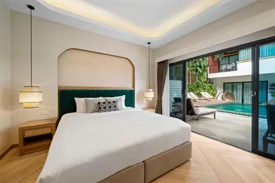 a bedroom with a large bed and a swimming pool at Buasri Boutique Patong in Patong Beach