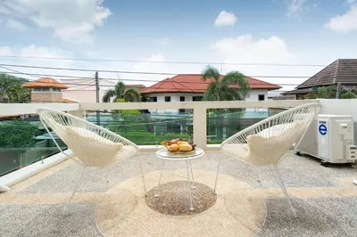 a balcony with two chairs and a table with fruit on it at Apartment 1 Bedroom in Naiharn t in Ban Saiyuan (1)